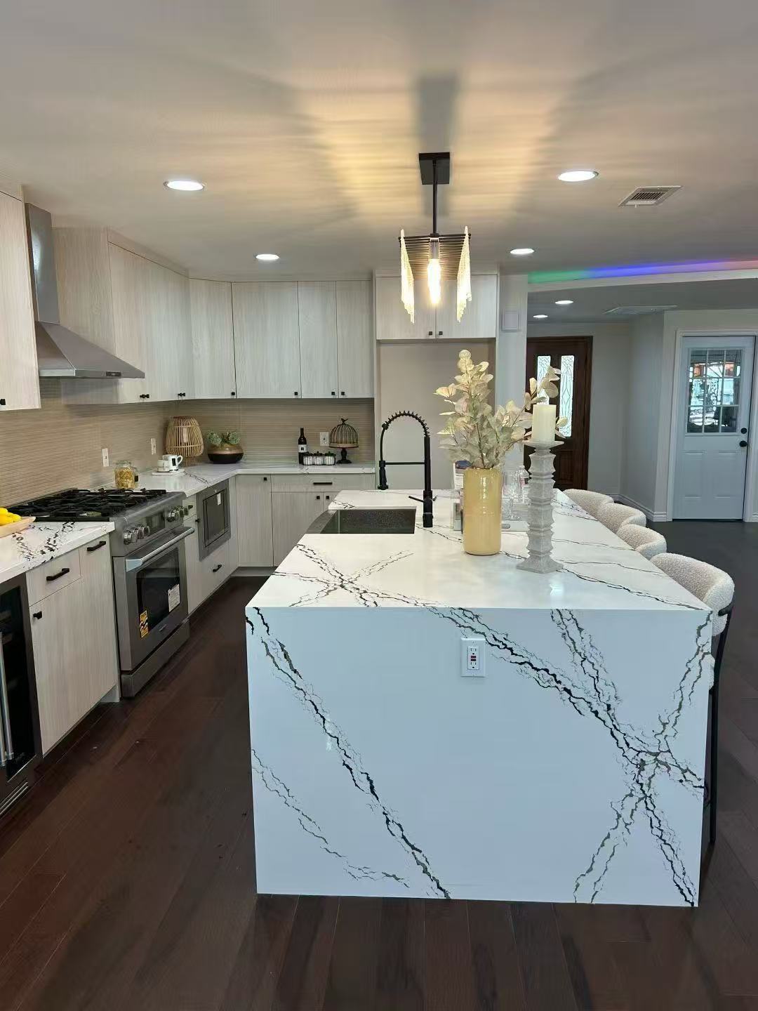 Modern multi-family kitchen perspective featuring Artisan White Oak laminate frameless cabinetry, integrated appliances, and prefab quartz countertops.