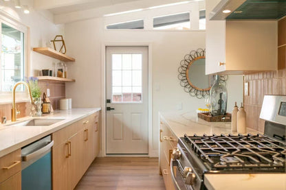 Modern kitchen build-out showcasing full-overlay Modern Oak laminate frameless cabinets with commercial-grade construction.
