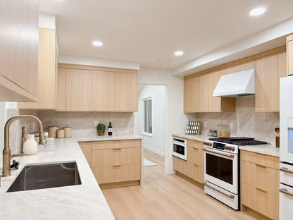 Bright contemporary commercial kitchen design featuring full-overlay Barcelona Light Oak laminate frameless cabinets.